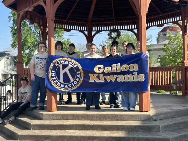 Galion Kiwanis volunteers holding a Kiwanis International banner during Arbor Day community cleanup in Galion, Ohio