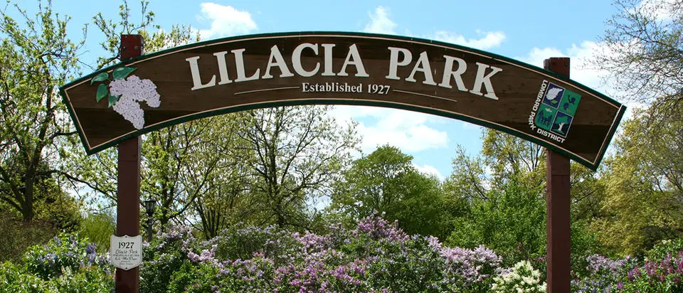 The Lilacia Park entrance sign framed by lilacs