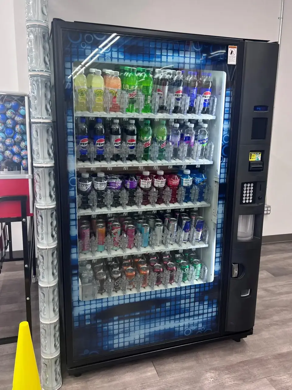 Drink vending machine inside Uptown Laundry offering a variety of beverages