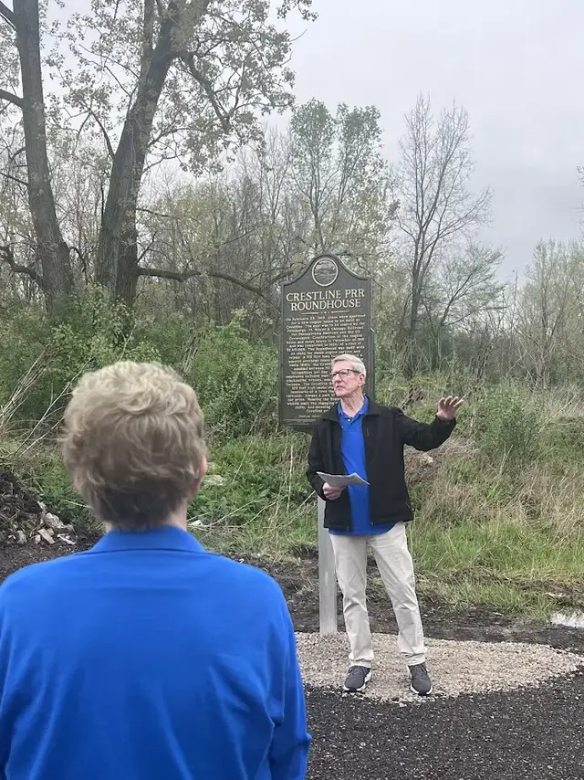 Speaker explains to crowd the history of the PRR Roundhouse and reads the marker.