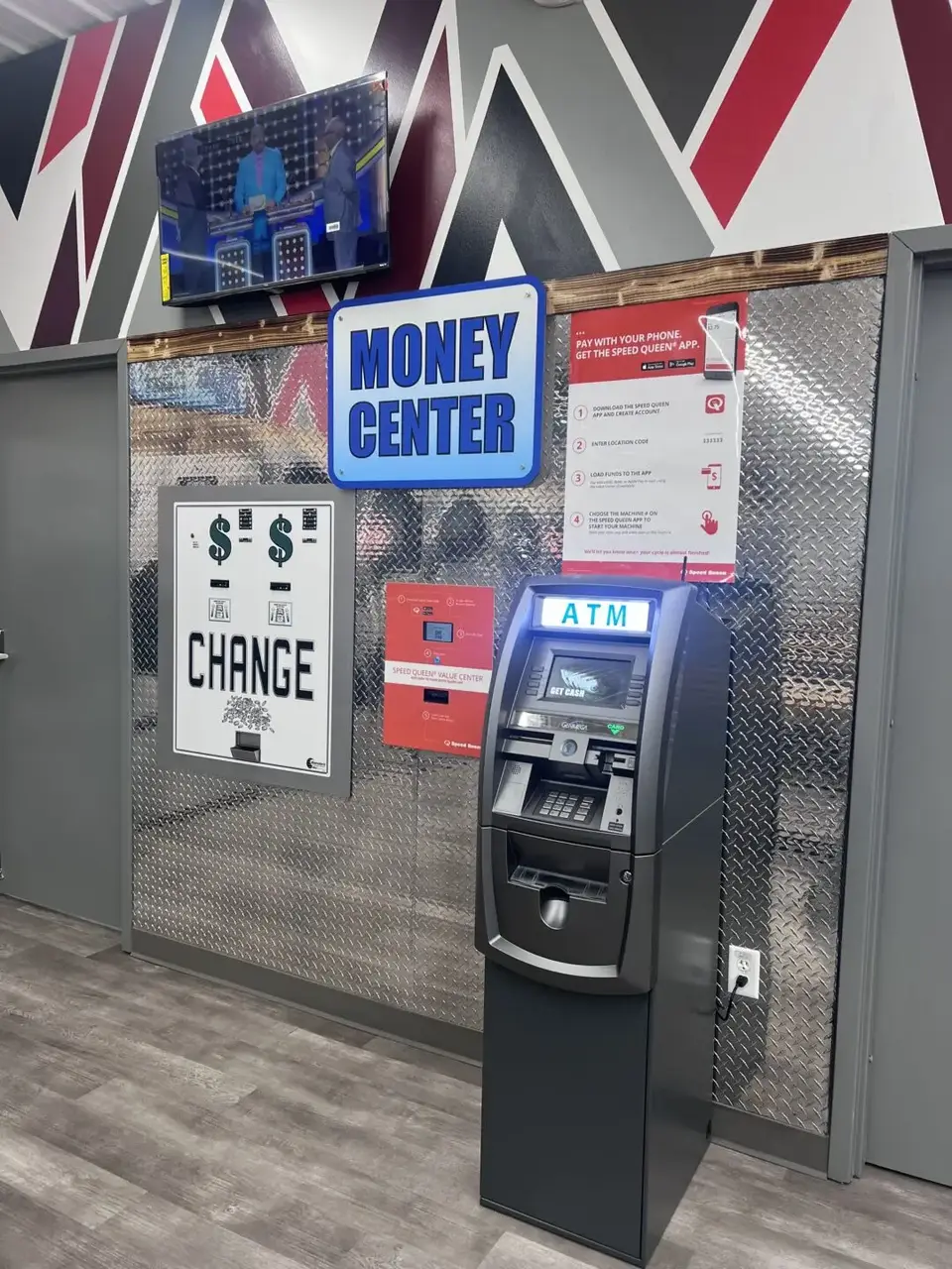 Money center area inside Uptown Laundry featuring an ATM and change machine for customer convenience.