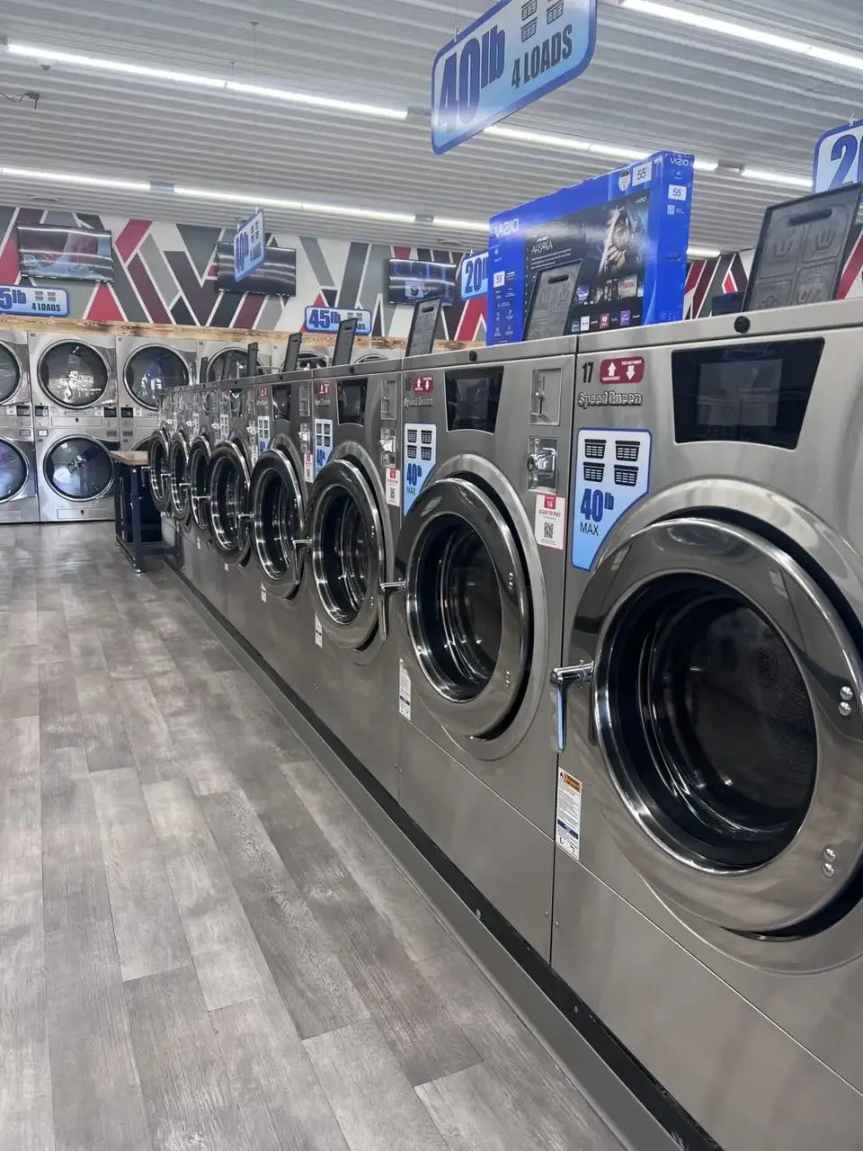 Row of modern, large-capacity front-loading washers inside Uptown Laundry in Bucyrus, Ohio.