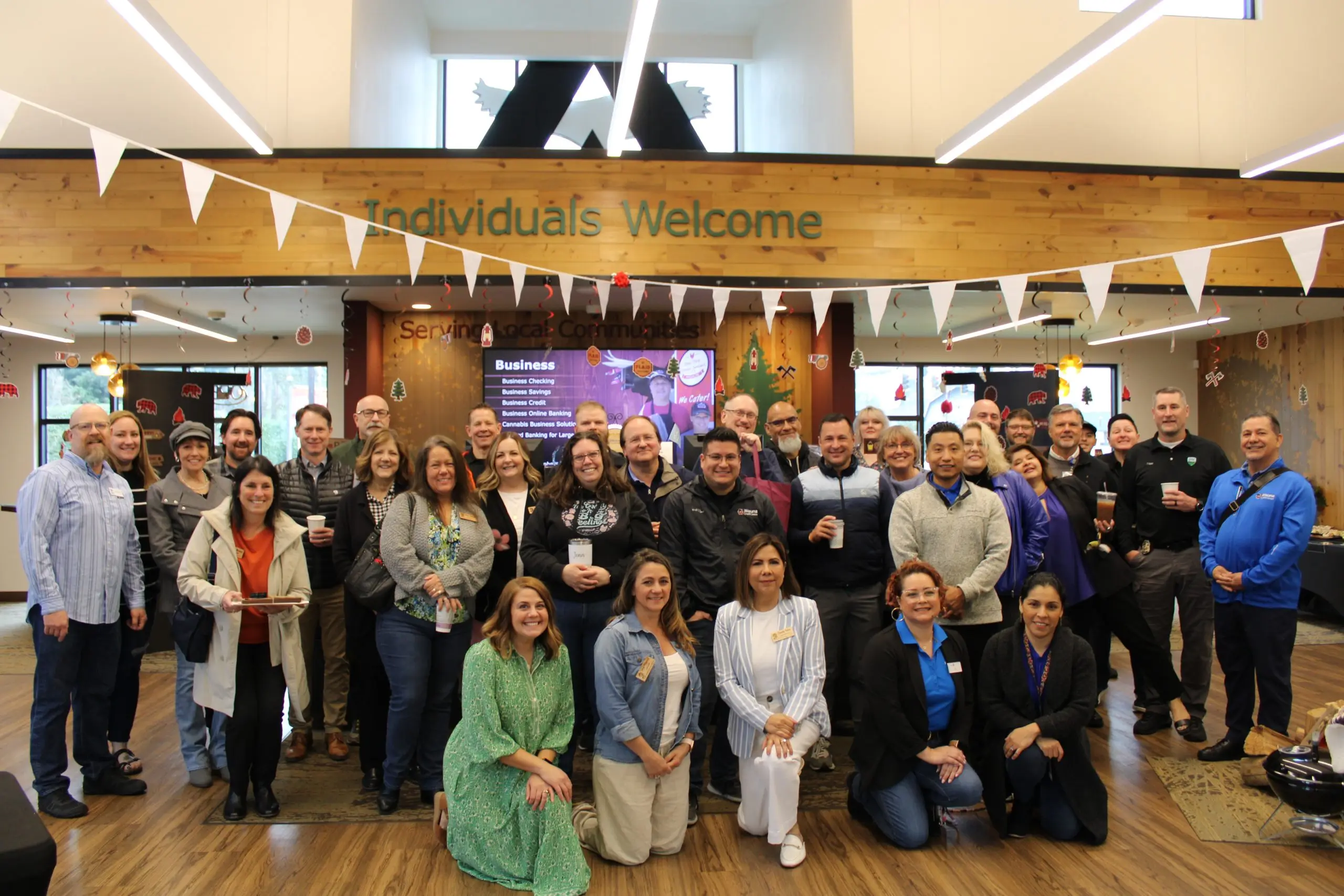 Chamber members posed together in a lobby hung with bunting.