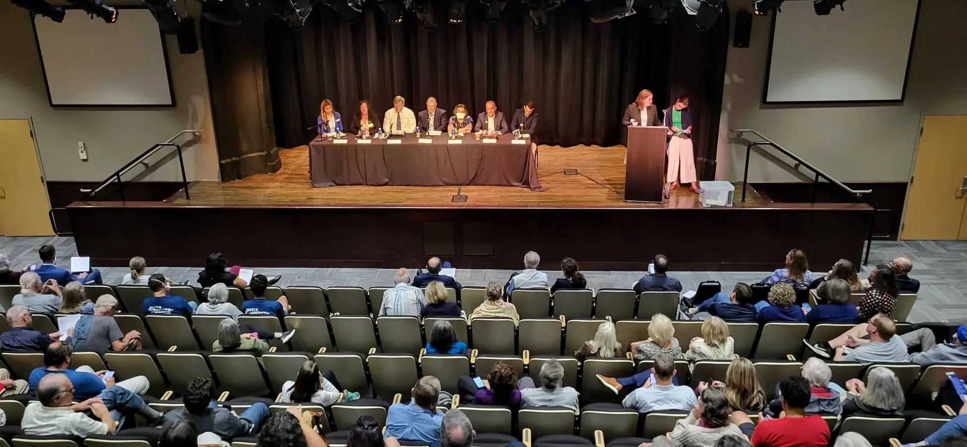 A city-council candidate panel on stage before a full audience